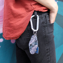 Load image into Gallery viewer, Keychain is seen attached to Rebellion 99 member&#39;s keys. Back side of keychain is shown.
