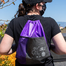 Load image into Gallery viewer, Rebellion 99 member shown from behind wearing the drawstring backpack.
